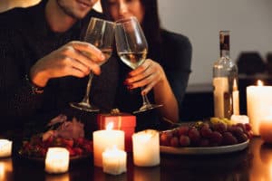 Couple drinking wine with candles and grapes