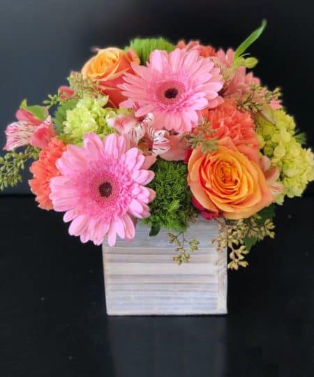 Mixed arrangement in citrus tones designed in a wood box. Includes pink, orange, and greens. Roses, Gerbera Daisies, Hydrangea, and more. 