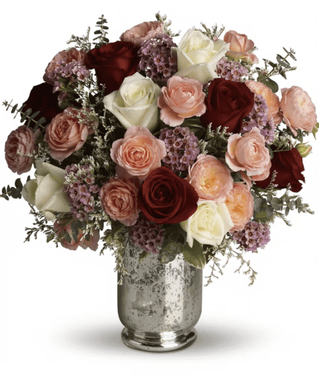 Let her know that you are always hers by sending this enchanting rose bouquet. It offers red roses for romance, white roses for loyalty, and coral to convey desire. What's more, this stunning arrangement is elegantly hand-delivered in a silver mercury glass hurricane vase.